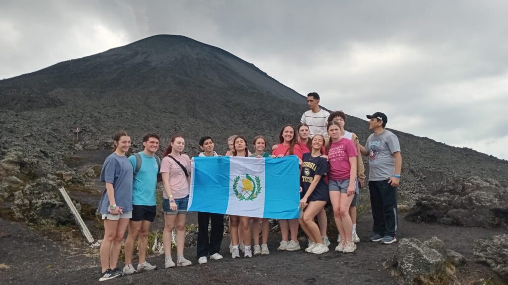 Grupo de Odyssey con la bandera de Guatemala en el Volcán Pacaya