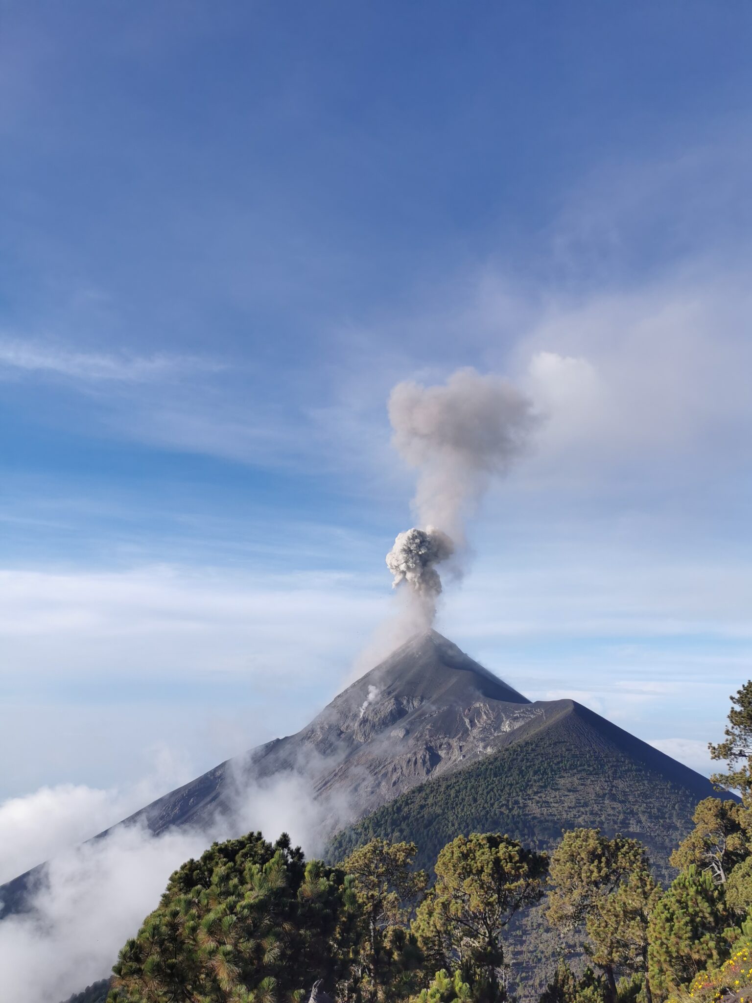 Volcán de Fuego lanzando una columna de ceniza sobre las nubes en Guatemala