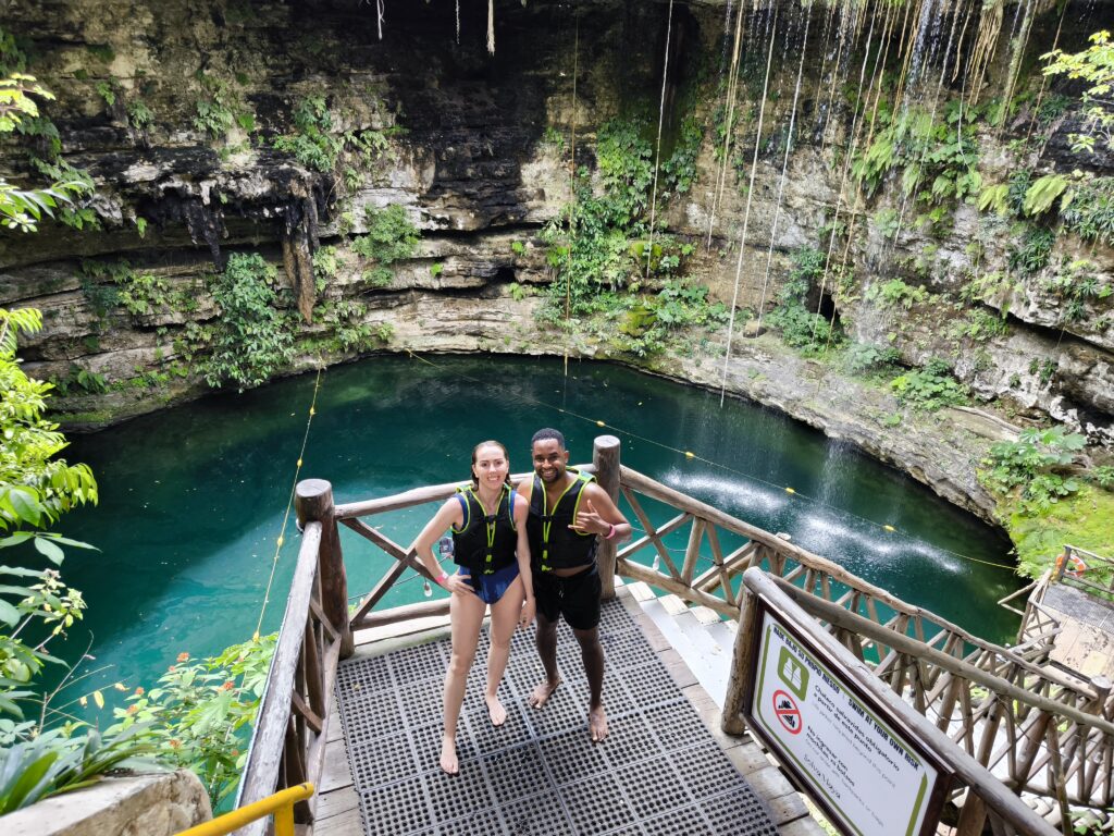 Travelers on the wooden platform of a jungle cenote