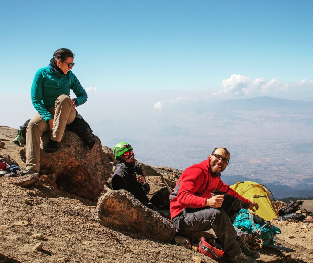 Guía de Odyssey descansando con viajeros en un volcán sobre las nubes