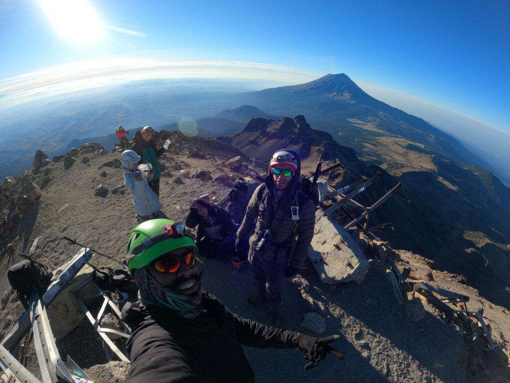 César and his group on the summit of Iztaccíhuatl with Popocatépetl in the background
