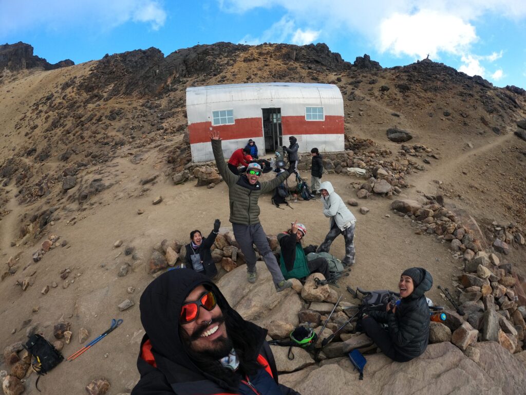 Group of climbers celebrating in front of a high-altitude hut on Iztaccíhuatl
