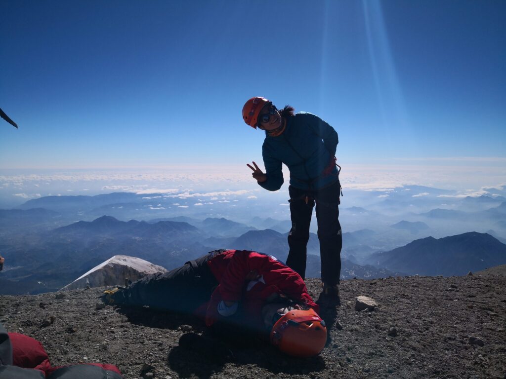 Climber on the summit of Pico de Orizaba above a sea of clouds